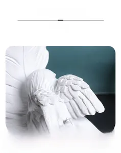 Detailed view of intricately carved white resin angel wings with realistic feather texture