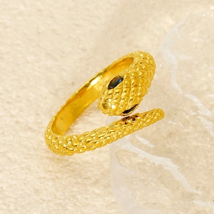 Macro shot of gold snake ring featuring detailed scales and black eye accents