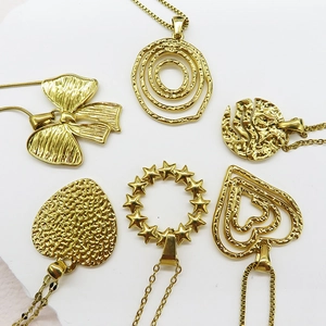 Detailed set of golden necklaces featuring bowknot, heart and textured round pendants