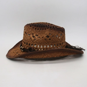 Detail of hollow woven straw cowboy hat with brown beads and decorative long tassels
