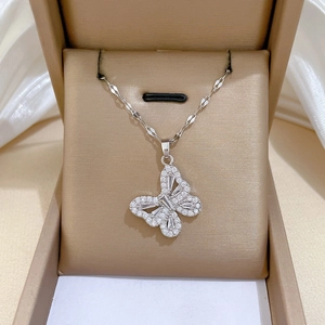 Detailed view of silver butterfly pendant with crystals in a brown jewelry gift box