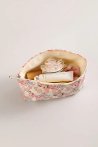 Detail view of cotton toiletry bag with pink bow pattern showing large inner capacity