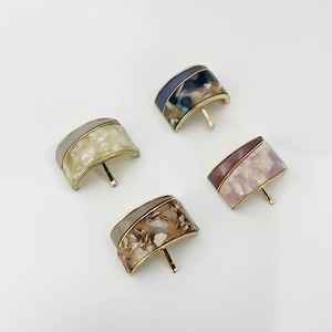 Close-up of four marble resin ponytail hooks with gold metal edge in various colors