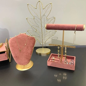 Pink velvet and gold metal jewelry display set with necklace stands and leaf organizer