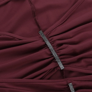 Makro-Detail von weinrotem gerafftem Stoff mit funkelndem Silber-Strass-Besatz-Dekor