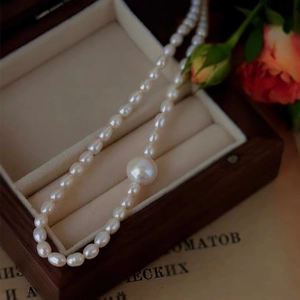 Elegant freshwater pearl necklace with round white pearls displayed in a vintage wooden box