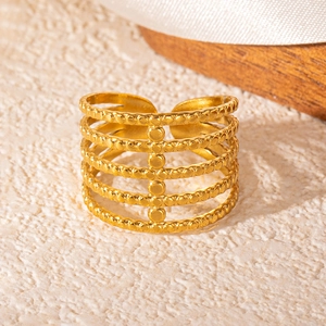 Detail view of gold snake-style layered ring with bead texture on wooden surface
