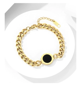 Close-up of gold-plated Roman numeral pendant and stainless steel Cuban chain bracelet