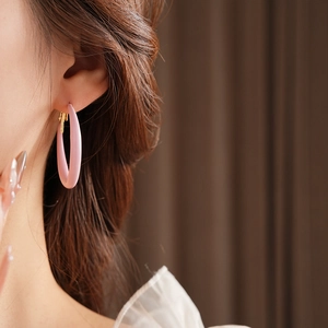 Close-up of pink matte resin hoop earring on model with golden metal pin detail