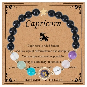Detailed macro view of Capricorn blue sandstone beaded bracelet on thematic card display