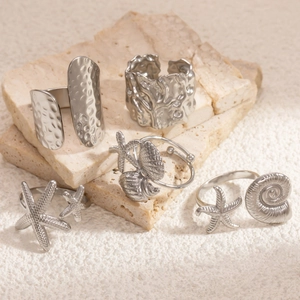 Detail shot of starfish and shell motifs on minimalist silver titanium steel rings