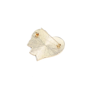 Detail of heart brooch back with golden metal finish and classic safety pin clasp