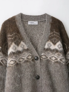 Detail of vintage jacquard knit cardigan with brown geometric pattern and soft texture
