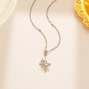 Detail of silver starburst cross necklace with clear zircon stones on a fine O-chain