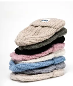 Close-up of thick knit beanies in various colors with a Lucky fabric label