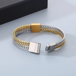 Macro detail of two-tone gold and silver fish scale steel chain bracelet with clasp
