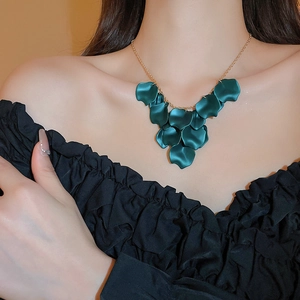 Elegant gold necklace featuring dark green flower petal tassels on a female model