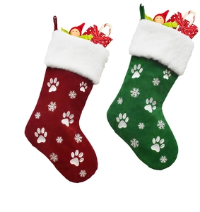 Detail of red and green Christmas stockings featuring silver paw prints and snowflake embroidery