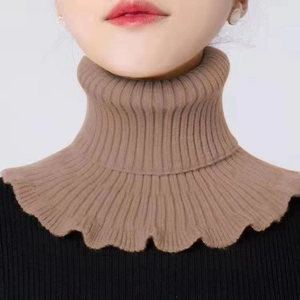 Primer plano de un cuello de punto camel con textura acanalada y dobladillo ondulado