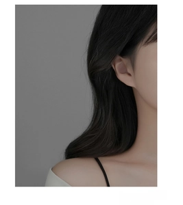 Close-up of a model wearing a delicate S925 silver butterfly stud earring in gold and white