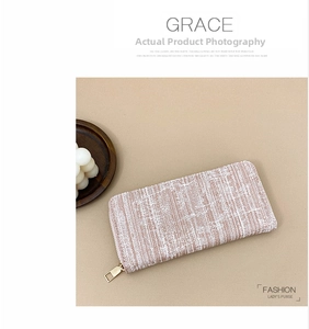 Detailed view of pink and white striped tweed women's long wallet with gold zipper