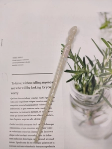 Close-up of pearl beige acetate hair pin with spiral pattern on a lifestyle magazine