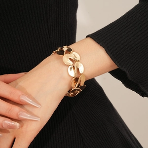 Close-up of a stylish gold metal S-shaped elastic拼接 bracelet on a model's wrist