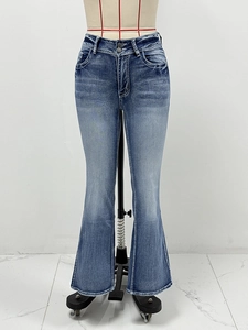 Detail of high-waisted blue flare jeans featuring double button closure and washed whiskers