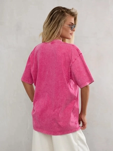 Macro detail of rose red acid washed cotton T-shirt showing vintage texture on the back