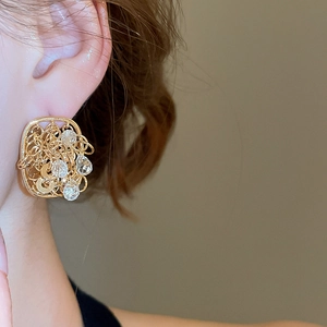 Close-up of 18k gold plated hollow square stud earring with clear crystals on model's ear