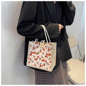 Close-up of small floral canvas handbag with white rope handle and wooden button detail