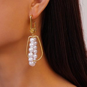 Elegant geometric gold metal earrings featuring nested faux pearls in a chic dangle style