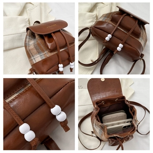 Makro-Detail des Retro-Karo-Rucksacks mit Kunstlederbesatz und Mode-Gravur-Elementen