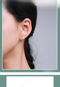 Detailed close-up of a heart-shaped S925 sterling silver stud earring on a model ear
