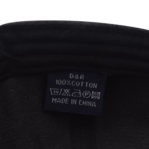 Detail of 100% cotton washing label and brand tag inside a black baseball cap