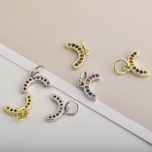 Detailed close-up of gold and silver horseshoe pendants with colorful zircon stones