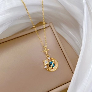 Detailed close-up of a gold star and moon necklace with blue opal stone on silk fabric