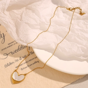 Detail of 18K gold-plated necklace featuring a shell heart pendant on a romantic card