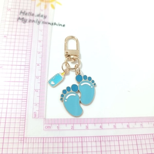 Baby blue footprint and milk bottle alloy charm keychain with golden clasp on pink grid
