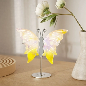 Artistic butterfly decor with yellow and purple watercolor wings on a silver metal base