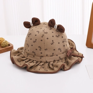 Vue détaillée du chapeau bébé en coton marron avec imprimé nœuds et oreilles 3D
