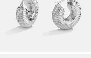 Silver chunky hoop earrings featuring textured ribbed metal surface and polished finish