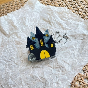 Macro shot of Halloween castle enamel pin with RIP gravestone on rustic tray