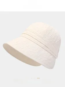 Close-up of the pleated texture and wide brim on a beige foldable sun bucket hat