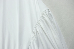 Detailed view of white pleated fabric and gathered stitching on the elegant V-neck maxi dress