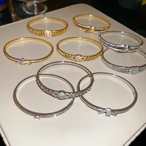 Bracelets plaqués or et argent avec zircons étincelants sur plateau en cuir chic