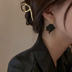 Elegant geometric gold and black drop earrings with matching metallic hair clip for women