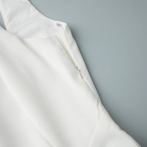 Détail d'une robe blanche avec fermeture éclair latérale invisible et tissu tissé