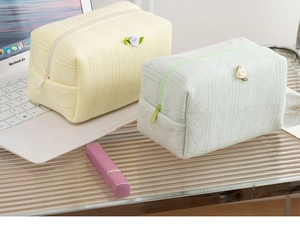 Dettaglio di pochette per cosmetici in maglia floreale giallo e verde ondulata