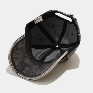 Detail view of washed denim baseball cap interior with 100% cotton label and metal buckle